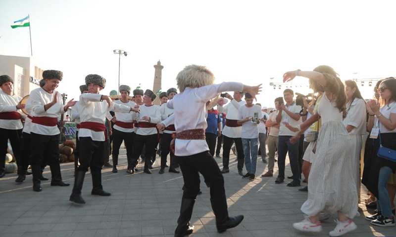 People celebrate the Melon Festival in Khiva, Uzbekistan, Aug. 11, 2024. Khiva in the Khorezm region of Uzbekistan hosted the annual Melon Festival from Aug. 9 to 11. The ancient city showcased a variety of melon products and held a series of vibrant traditional folk celebrations during the festival. （Photo: Xinhua)