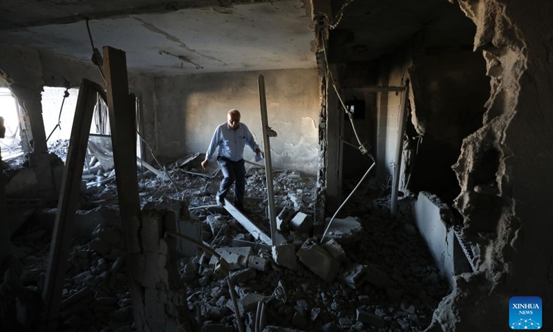 A man is seen in an apartment demolished by Israeli forces in the West Bank city of Ramallah, on Aug. 13, 2024. (Photo: Xinhua)