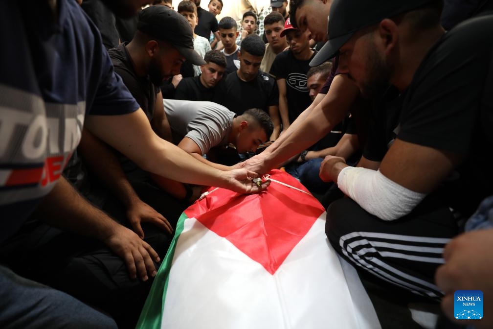 Relatives mourn over the body of Palestinian Moataz Sarsour killed by Israeli forces during his funeral at the al-Am'ari refugee camp near the West Bank city of Ramallah, on Aug. 13, 2024. (Photo: Xinhua)