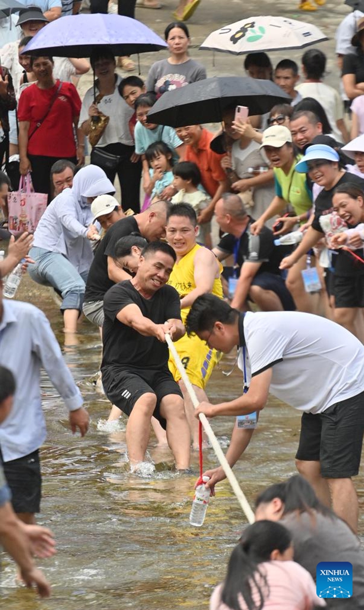 Villagers take part in a tug-of-war contest in Wangdong Township of Rongshui Miao Autonomous County in south China's Guangxi Zhuang Autonomous Region, Aug. 18, 2024. In recent years, Wangdong Township has leveraged its abundant water resources to promote rural vitalization. Supported by the pairing assistance from Lianjiang City in Guangdong Province, the township has organized water sports competitions, mountain song duets, and activities under the theme of intangible cultural heritage in schools. These initiatives aim to build a water culture brand and advance the development of ethnic cultural tourism. Photo: Xinhua