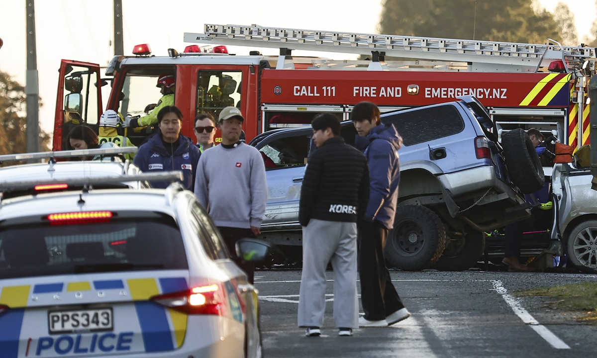 Men stand near damaged vehicles at a crash site near Geraldine, New Zealand, where South Korean skiers were involved in a fatal accident on August 22, 2024. A head-on collision at a local highway killed three South Korean skiers who were in New Zealand for training, and seriously injured two others. Photo: VCG