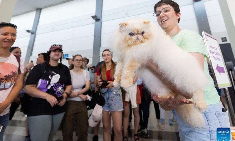 A woman shows her pet cat as people watch during the Cat Show at the 2024 Canadian National Exhibition (CNE) in Toronto, Canada, on Aug. 24, 2024. More than 100 pet cats across Canada participated in this annual event from Aug. 24 to 25. (Photo by Zou Zheng/Xinhua)