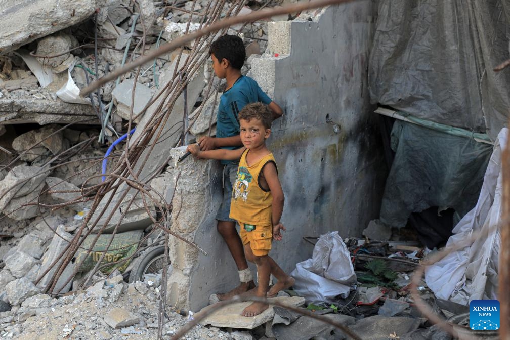 Children are pictured among rubble of damaged buildings in the southern Gaza Strip city of Khan Younis, on Aug. 26, 2024. (Photo: Xinhua)
