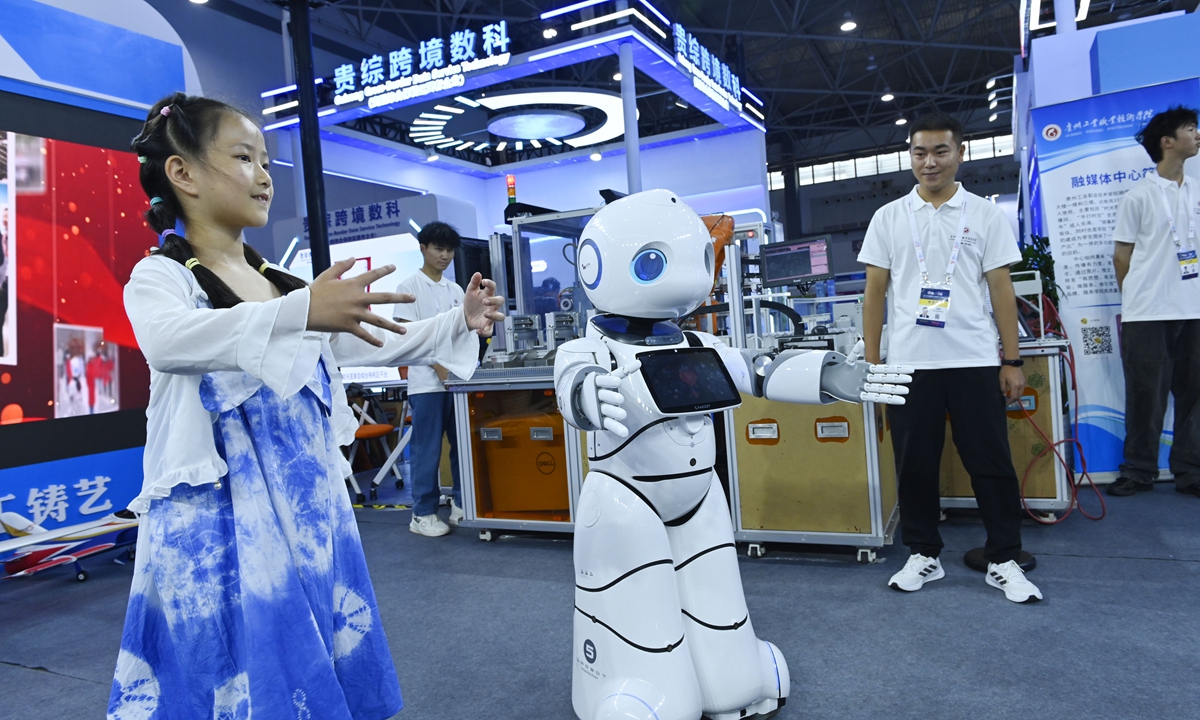 A child plays with a robot at the China International Big Data Industry Expo 2024?in Guiyang, capital city of Southwest China's Guizhou Province. The expo, themed 