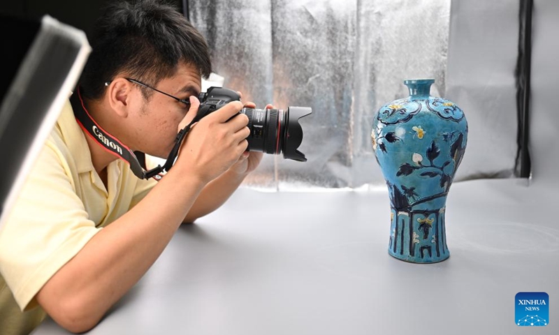 A staff member of China (Hainan) Museum of the South China Sea takes photos of cultural relics in Qionghai City, south China's Hainan Province, Aug. 27, 2024. At China (Hainan) Museum of the South China Sea, there is a cultural relic restoration team conducting the protection work of cultural relics retrieved from two ancient shipwrecks in the South China Sea. (Photo: Xinhua)