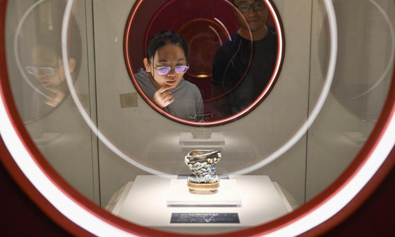 Visitors look at an exhibit on a special exhibition at Hainan Museum in Haikou, south China's Hainan Province, Aug. 31, 2024. An ongoing exhibition showcasing Hainan's cultural relics collected by the Palace Museum is held at Hainan Museum. A total of 96 exhibits with Hainan characteristics are on display including traditional furniture, ornaments and stationery, etc. (Xinhua/Pu Xiaoxu)