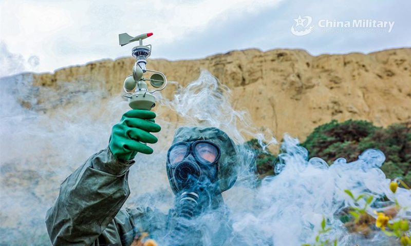 A soldier assigned to a chemical defense detachment of a brigade under the PLA 76th Group Army detects wind direction during a battlefield comprehensive protection training exercise on July 16, 2024. (eng.chinamil.com.cn/Photo by Li Mingxu)