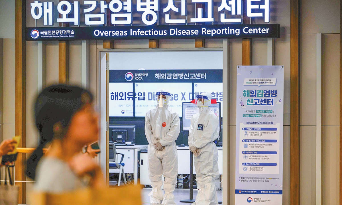 A passenger walks past airport staff members standing in the Overseas Infectious Disease Reporting Center at Incheon International Airport in Seoul, South Korea on September 3, 2024 in a training drill to respond to an influx of new infectious diseases. South Korea redesignated monkeypox, now renamed Mpox, as an infectious disease subject to border screening on August 21. Photo: VCG