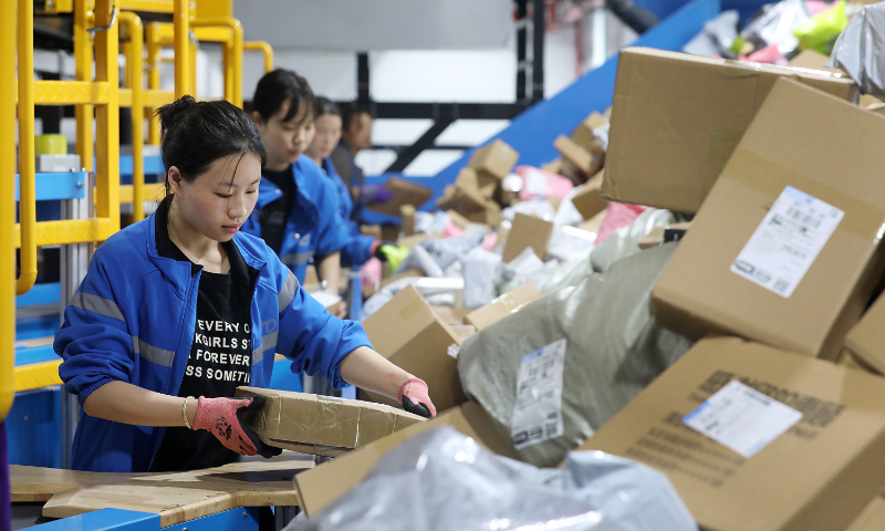 Workers sort parcels at an express delivery center in Yiwu, East China's Zhejiang Province, on October 30, 2024. The volume of express deliveries in Yiwu doubled as several e-commerce platforms started the