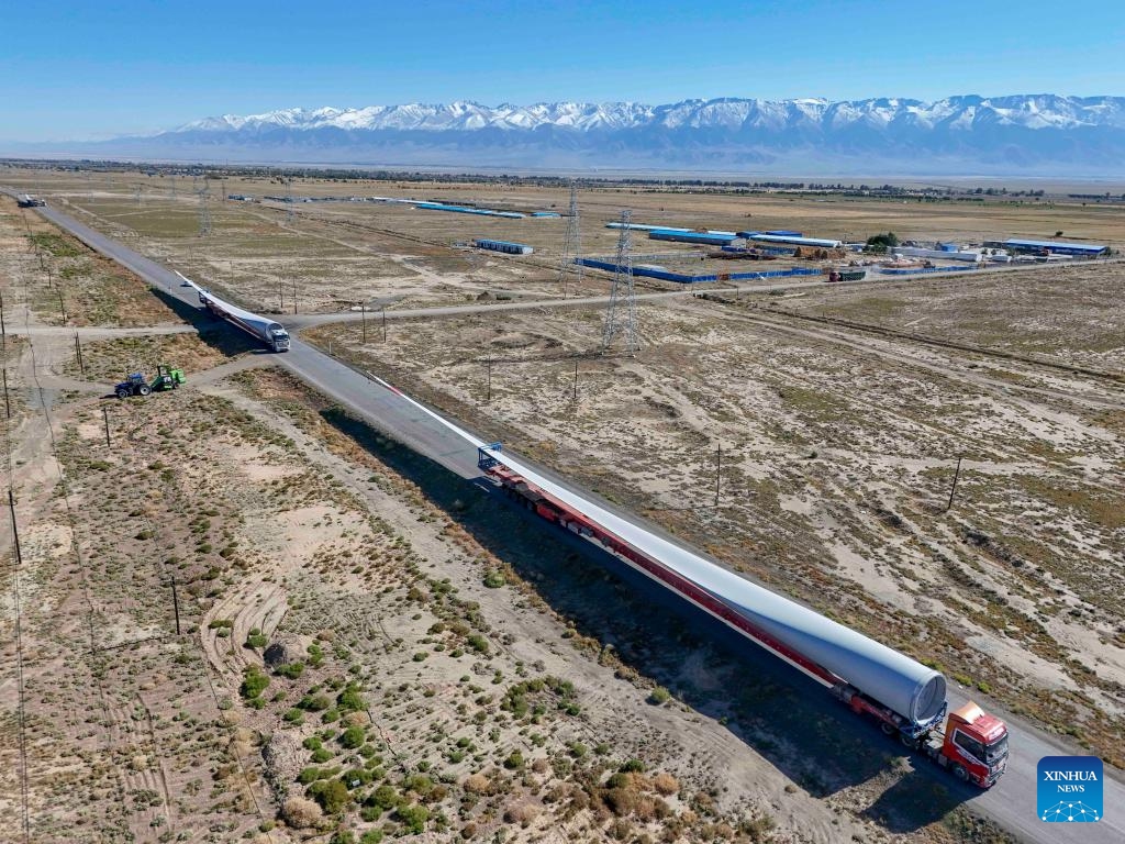 An aerial drone photo taken on Sept. 10, 2024 shows trucks transporting wind turbine blades in Kazak Autonomous County of Barkol, northwest China's Xinjiang Uygur Autonomous Region. Rich in wind energy resources, Hami is one of the country's major wind power bases. Making the best use of resource advantages, the city has accelerated the development and construction of wind power in recent years to promote green transformation of energy. (Photo: Xinhua)
