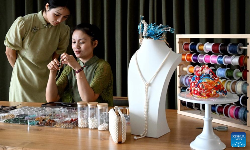 Chu Mengdan (R) teaches her apprentice bead weaving skills at an intangible cultural heritage experience hall in Luoyang City, central China's Henan Province, Sept. 12, 2024. (Photo: Xinhua)