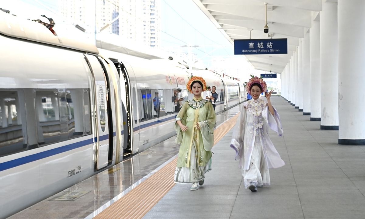 Passengers pose beside a train in Xuancheng railway station in East China's Anhui Province on October 11, 2024 as the Xuanji High-Speed Rail commenced operations. The main line of the Xuanji rail spans 115 kilometers, bringing the operational length of the high-speed rail network in the Yangtze River Delta region to over 7,600 kilometers. Photo: VCG
