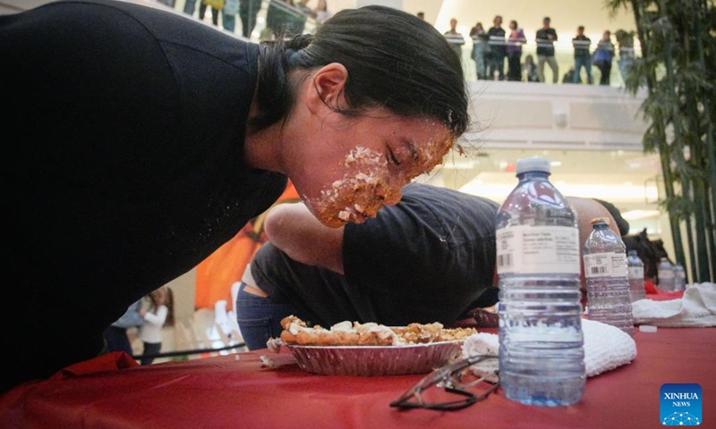 People compete during the pumpkin pie eating contest at Metrotown Shopping Mall in Burnaby, British Columbia, Canada, Oct. 19, 2024.
The competition required participants to finish as much of a 2-pound pie as possible in 5 minutes without using their hands. (Photo: Xinhua)