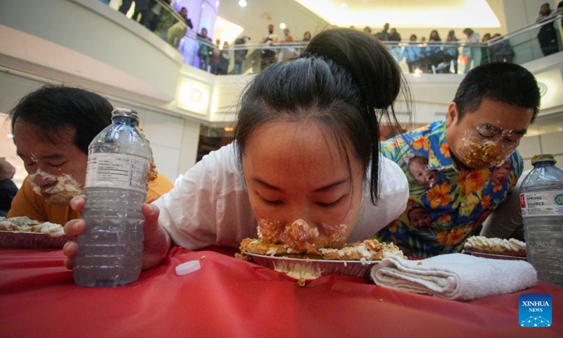 People compete during the pumpkin pie eating contest at Metrotown Shopping Mall in Burnaby, British Columbia, Canada, Oct. 19, 2024.
The competition required participants to finish as much of a 2-pound pie as possible in 5 minutes without using their hands. (Photo: Xinhua)