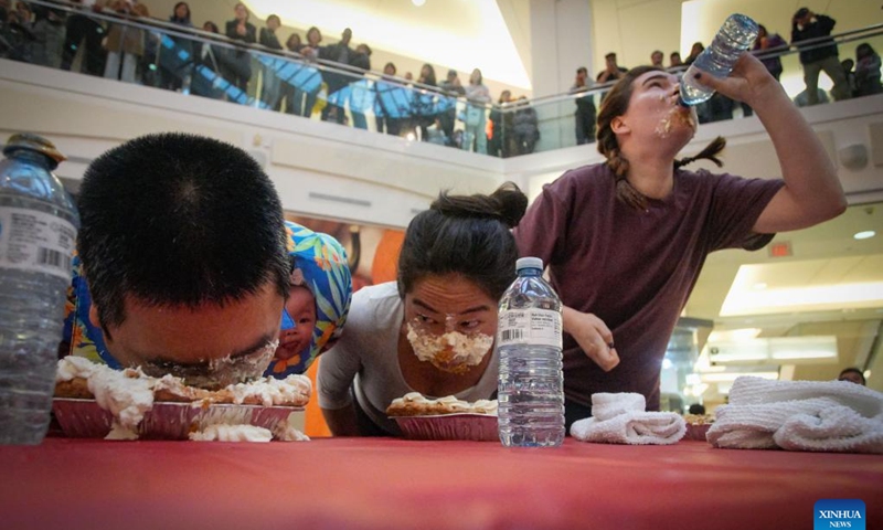 People compete during the pumpkin pie eating contest at Metrotown Shopping Mall in Burnaby, British Columbia, Canada, Oct. 19, 2024.
The competition required participants to finish as much of a 2-pound pie as possible in 5 minutes without using their hands. (Photo: Xinhua)