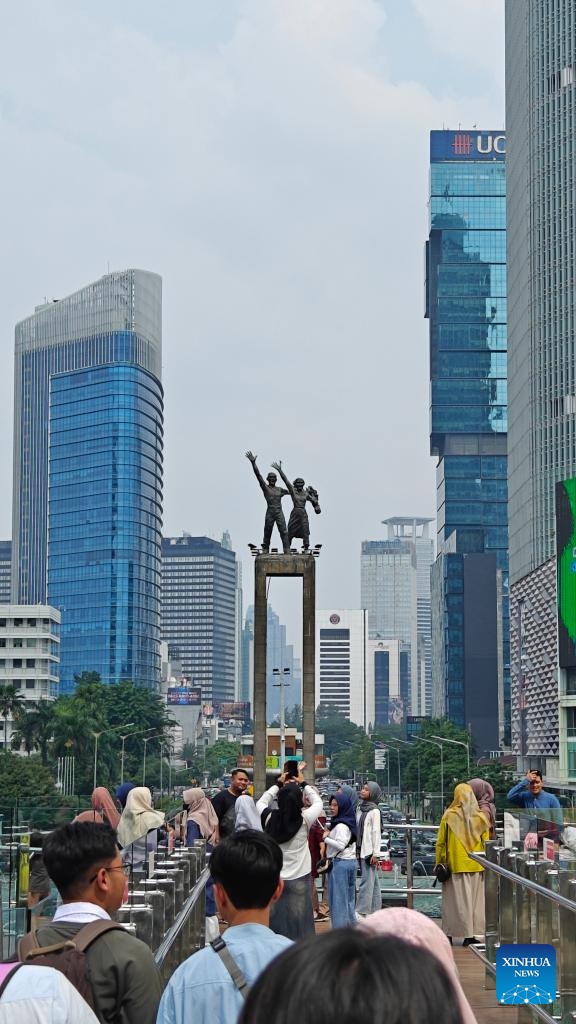 This photo taken with a mobile phone shows people taking photos with Selamat Datang Monument on a nearby observation deck in Jakarta, Indonesia, July 10, 2024. Located on the northwest coast of Java Island, Jakarta is the largest city in Indonesia and is currently the political, economic and cultural center of the country. (Photo: Xinhua)