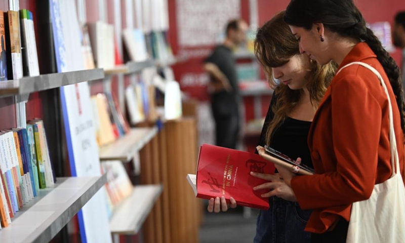 People read a book at the Chinese exhibition booth during the Malta Book Festival in Ta' Qali, Attard, Malta, on Nov. 6, 2024. A delegation of Chinese publishers, alongside the China Cultural Center in Malta, showcased a variety of Chinese publications at the 45th Malta Book Festival, which runs from Nov. 6 to Nov. 10 in Attard, central Malta. (Photo: Xinhua)