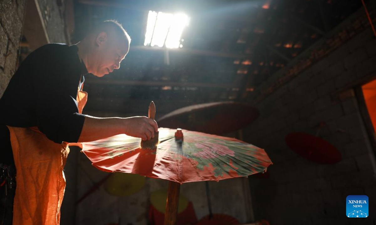 Zheng Guomin, a provincial-level inheritor of intangible cultural heritage, makes oilcloth umbrella at Guomin Oilcloth Umbrella Plant in Gufeng Village of Jingxian County, east China's Anhui Province, Nov. 13, 2024. The umbrella, made of oiled cloth and bamboo frame, is a traditional Chinese handicraft. (Photo: Xinhua)