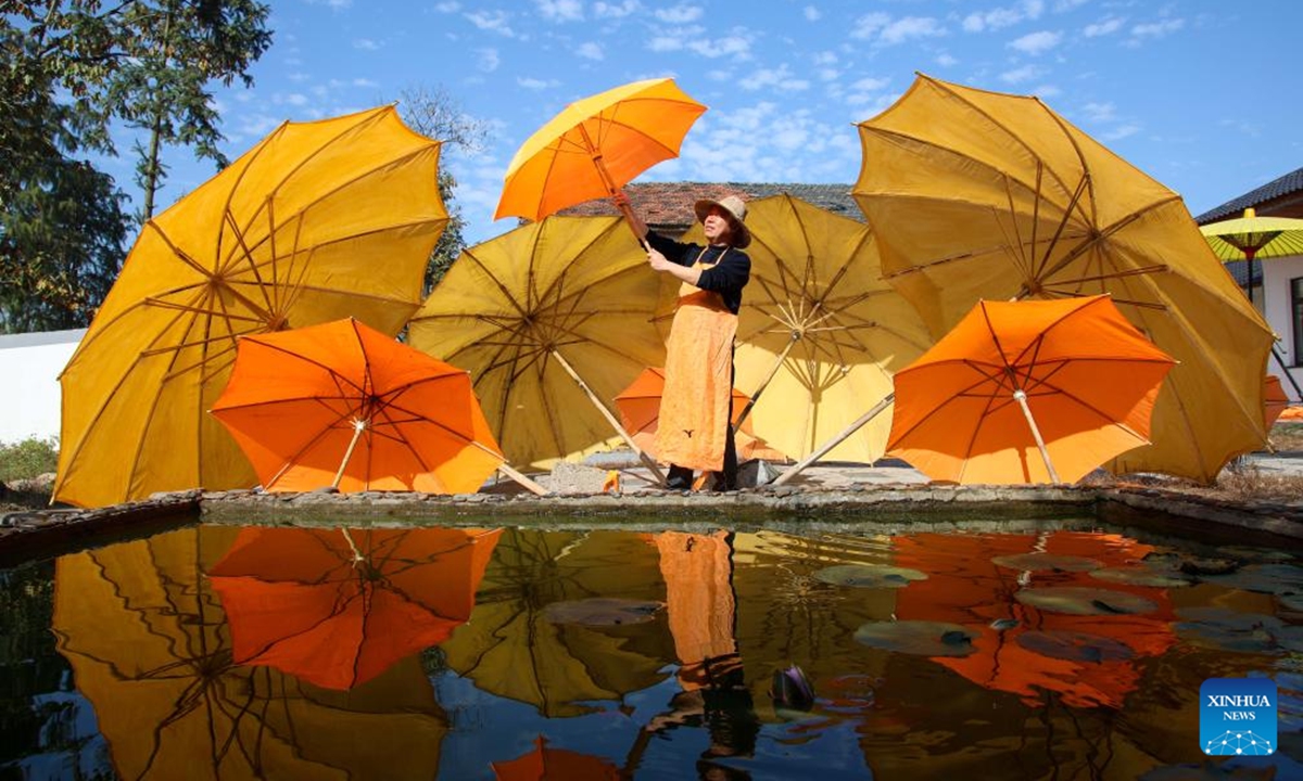 A worker airs oilcloth umbrellas in Gufeng Village of Jingxian County, east China's Anhui Province, Nov. 13, 2024. The umbrella, made of oiled cloth and bamboo frame, is a traditional Chinese handicraft. (Photo: Xinhua)