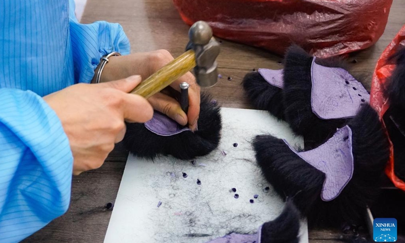 A staff member makes stuffed panda toy parts out of sheepskin at a workshop of Panda Factory in Heze, east China's Shandong province, March 12, 2024.(Xinhua)
