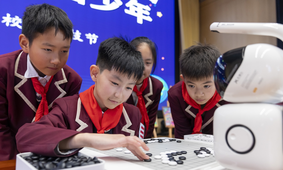 An elementary school student plays Go against AI robots in Nantong, East China's Jiangsu Province, on November 26, 2024. The school has been holding a science and technology festival over the past few days, during which children experienced the charm of technology, thus sparking their interest in science through visual experiences, technological innovations, and technical challenges. Photo: VCG