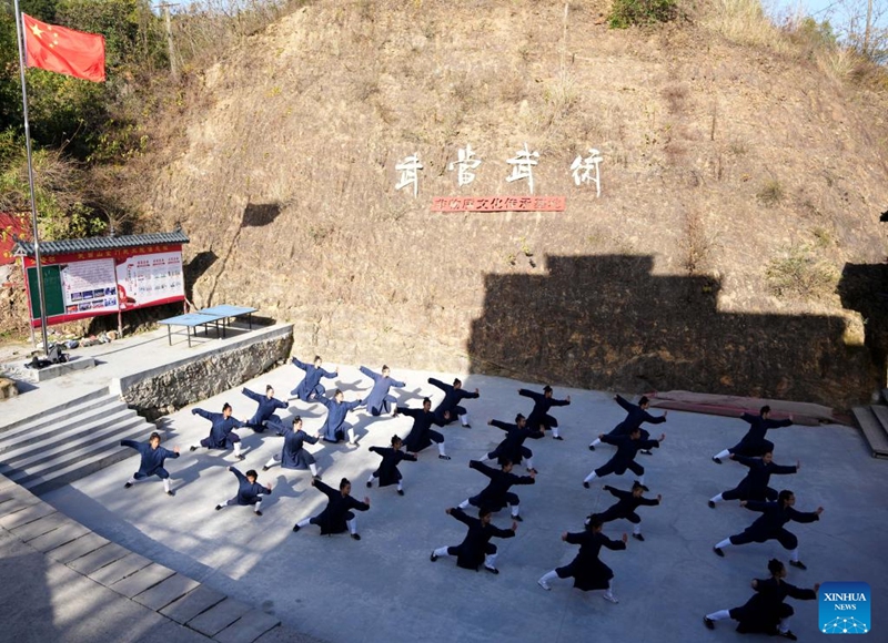 Students practice Tai Chi at a martial arts school in Shiyan City in central China's Hubei Province, Nov. 28, 2024. Tai Chi, a centuries-old Chinese martial art focusing on both internal and external practices, involves a series of slow, gentle movements and physical postures, a meditative state of mind, and controlled breathing. Statistics show that over 100 million people across more than 150 countries and regions practice Tai Chi, with about 30,000 foreigners traveling to the Wudang Mountain annually to learn and experience it. Photo: Xinhua