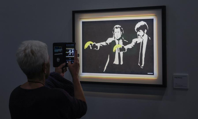 A visitor views an artwork of British street artist Banksy during the exhibition The Art of Banksy in Wellington, New Zealand, on De. 3, 2024. Photo: Xinhua