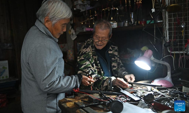 A 91-year-old craftsman fixes a hand-held steelyard for a villager, at the Youbu ancient town of Lanxi City, east China's Zhejiang Province, Dec. 5, 2024. Youbu ancient town, with a history of more than 1,300 years, is well known for its morning tea and photography elements and attracts a large number of tourists. (Photo: Xinhua)
