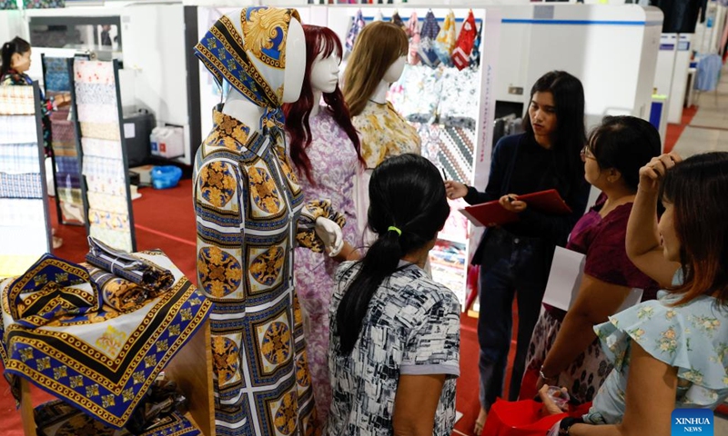 People visit an exhibition booth during the 2024 Myanmar International Textile and Machinery Fair in Yangon, Myanmar, Dec. 6, 2024. The 2024 Myanmar International Textile and Machinery Fair kicked off in Yangon on Friday. (Photo: Xinhua)