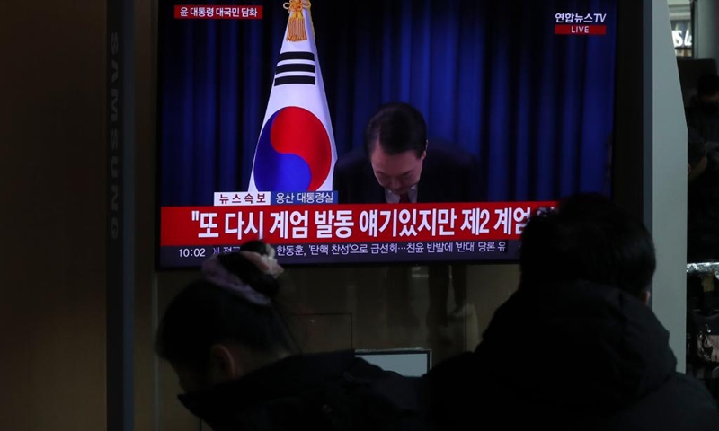 People watch a televised address delivered by South Korean President Yoon Suk-yeol on a screen at a railway station in Seoul, South Korea, Dec. 7, 2024. Yoon apologized for his martial law declaration during a televised address to the nation on Saturday. Photo: Xinhua