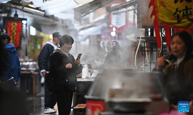 A tourist visits a morning tea street at the Youbu ancient town of Lanxi City, east China's Zhejiang Province, Dec. 5, 2024. Youbu ancient town, with a history of more than 1,300 years, is well known for its morning tea and photography elements and attracts a large number of tourists. Photo: Xinhua
