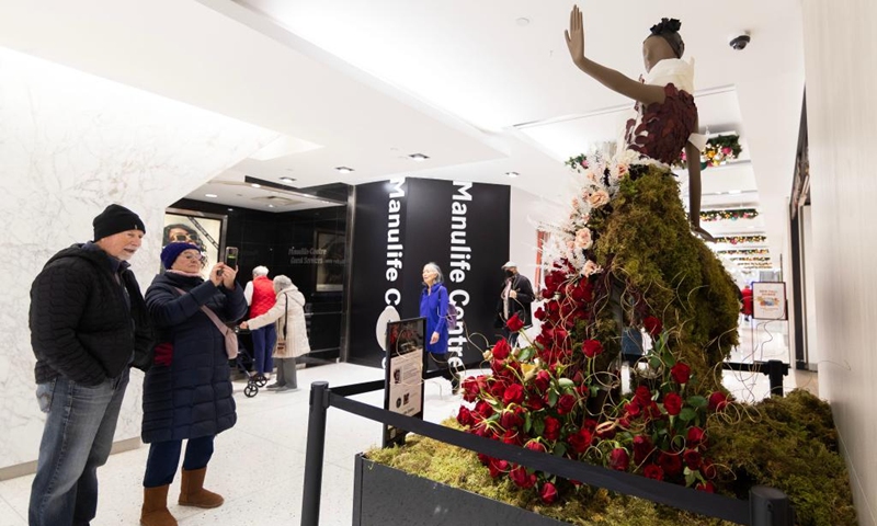 A woman films a floral installation on display during the Fleurs de Villes NO?L event in Toronto, Canada, on Dec. 6, 2024. The event is held here from Dec. 4 to Dec. 8, featuring 30 floral installations. Photo: Xinhua
