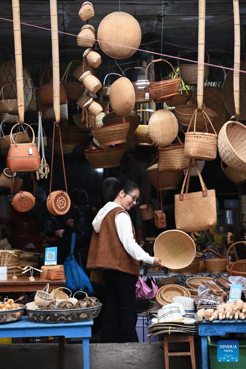 A tourist selects products at a handcraft shop at the Youbu ancient town of Lanxi City, east China's Zhejiang Province, Dec. 5, 2024. Youbu ancient town, with a history of more than 1,300 years, is well known for its morning tea and photography elements and attracts a large number of tourists. Photo: Xinhua