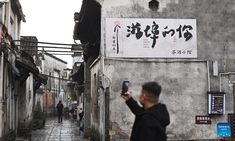 A tourist takes photos of ancient buildings at the Youbu ancient town of Lanxi City, east China's Zhejiang Province, Dec. 5, 2024. Youbu ancient town, with a history of more than 1,300 years, is well known for its morning tea and photography elements and attracts a large number of tourists. Photo: Xinhua