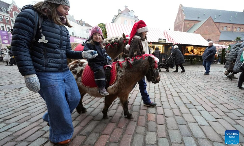 A girl enjoys a pony ride at a Christmas market in Riga, Latvia, Dec. 7, 2024. Photo: Xinhua