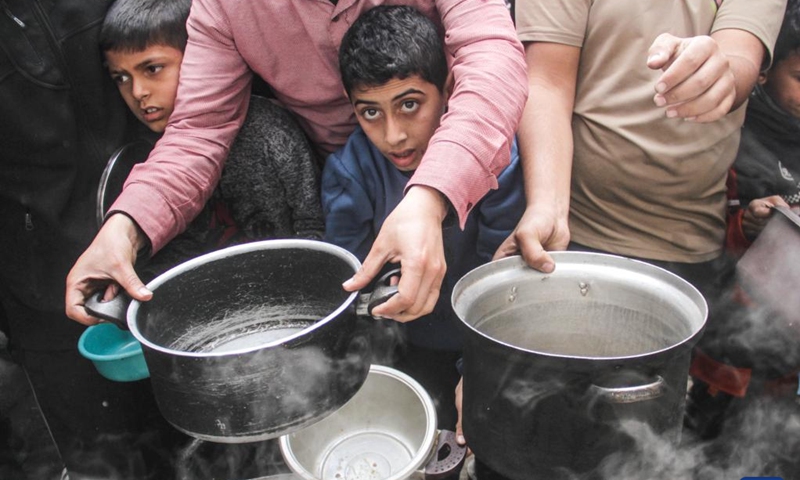 Displaced Palestinians try to get food aid from a local community kitchen amid the siege imposed by the Israeli army and the scarcity of aid in the Al-Shati camp, west of Gaza City, on Dec. 7, 2024. Photo: Xinhua