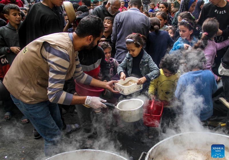 Displaced Palestinians try to get food aid from a local community kitchen amid the siege imposed by the Israeli army and the scarcity of aid in the Al-Shati camp, west of Gaza City, on Dec. 7, 2024. Photo: Xinhua