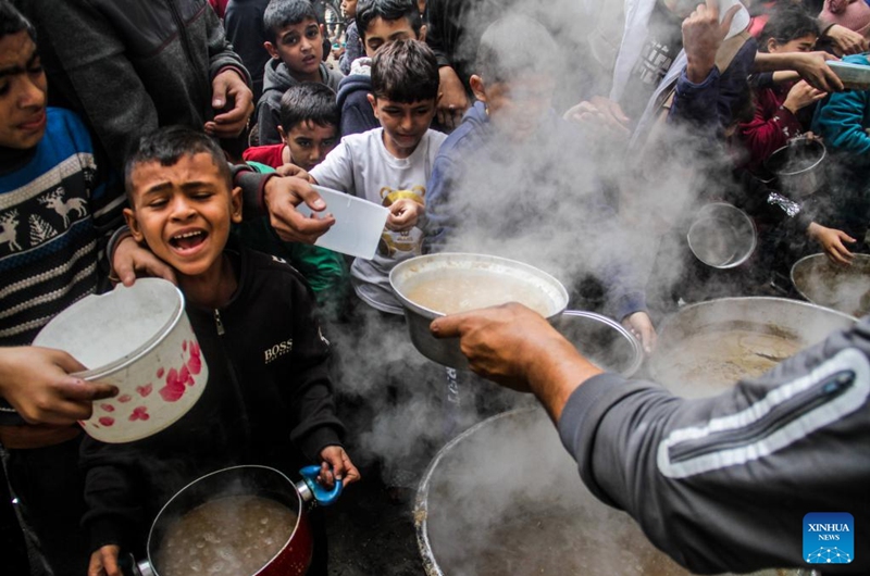 Displaced Palestinians try to get food aid from a local community kitchen amid the siege imposed by the Israeli army and the scarcity of aid in the Al-Shati camp, west of Gaza City, on Dec. 7, 2024. Photo: Xinhua