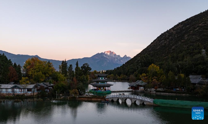 A drone photo taken from Heilongtan Park shows sunlight shining on the Yulong Snow Mountain in Lijiang City, southwest China's Yunnan Province, Dec. 9, 2024. (Photo: Xinhua)
