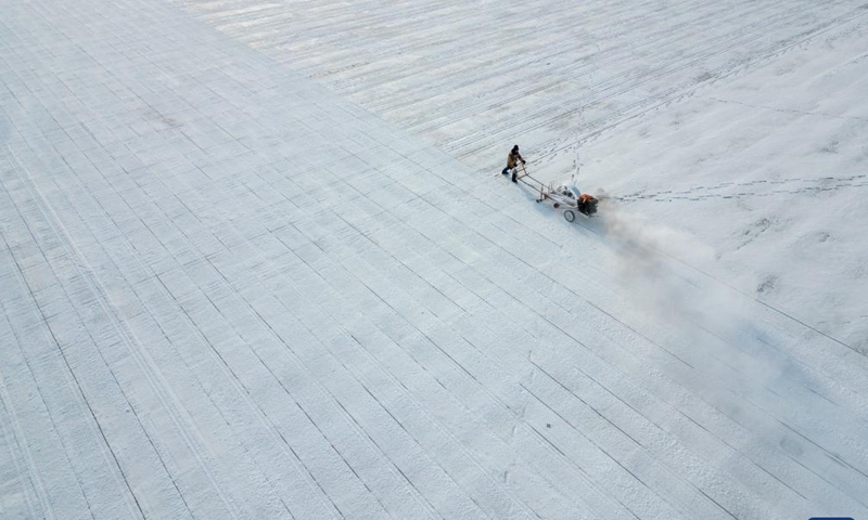 An aerial drone photo taken on Dec. 9, 2024 shows a worker collecting ice from the Songhua River in Harbin, capital of northeast China's Heilongjiang Province. As the ice collection season starts, ice cubes are being cut out and elevated from the frozen Songhua River for scenery building at tourist attractions cross the city. The most prominent one of them is the Harbin Ice-Snow World, a renowned seasonal theme park in the city that enjoys great popularity every winter. (Photo: Xinhua)