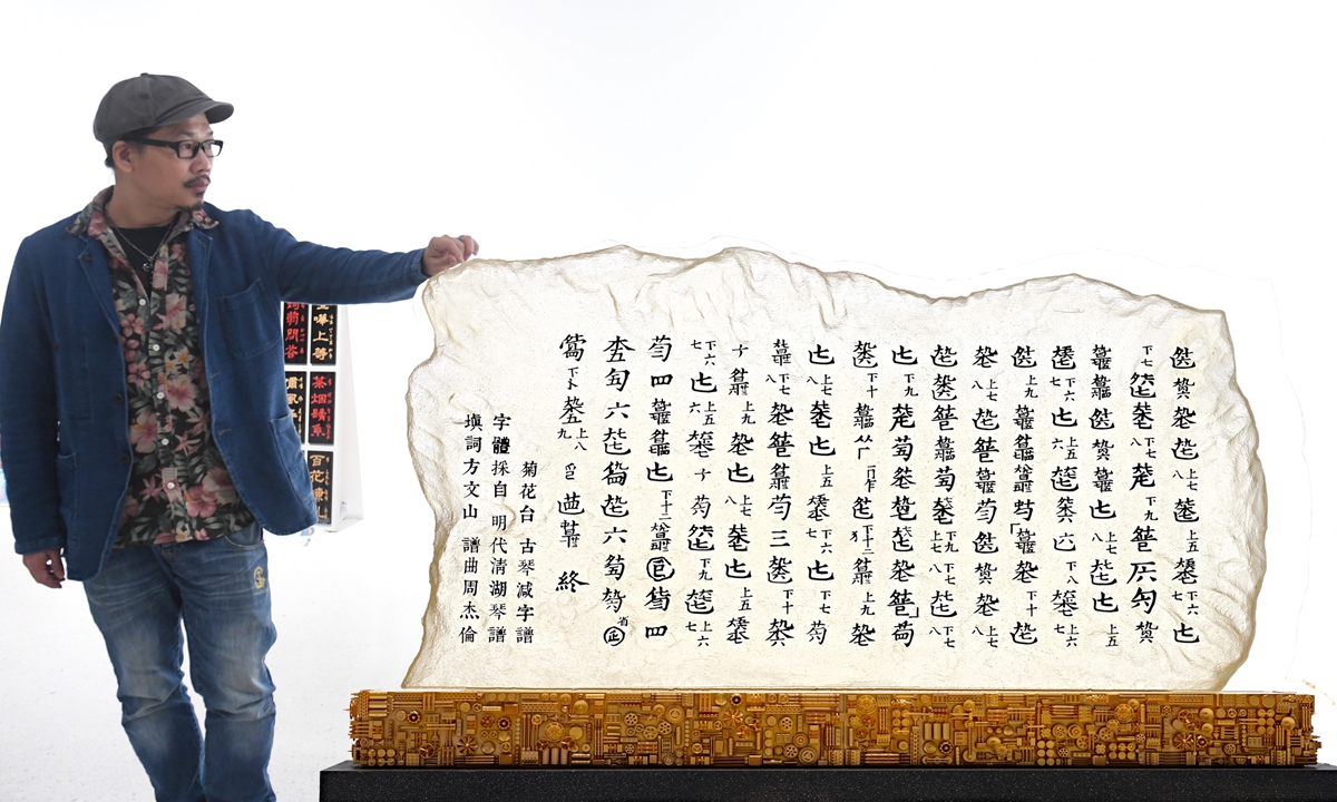 Vincent Fang Wenshan poses beside the Chinese sheet music for the guqin cover of a song sung by Jay Chou, the lyrics of which were penned by Fang. Photo: VCG