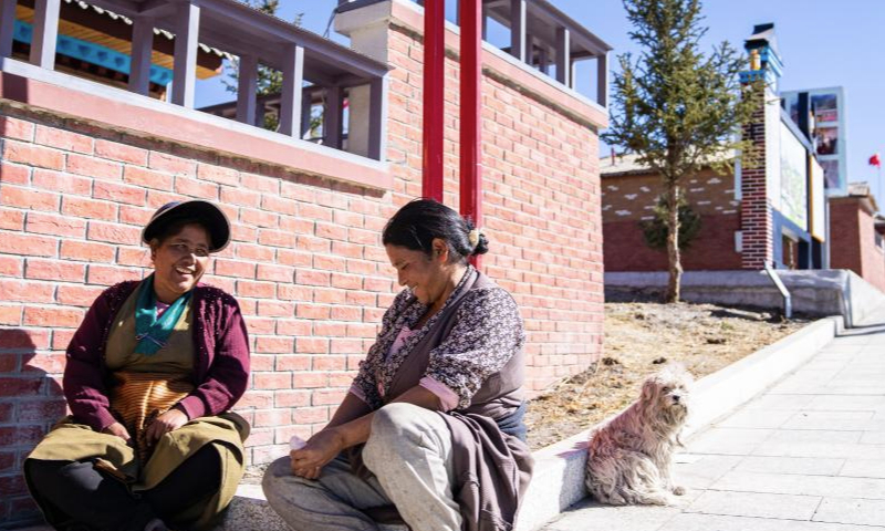 Women chat outside their residency at the new Daman Village in Jilung Town of Xigaze in southwest China's Xizang Autonomous Region, Dec. 15, 2024. The new Daman Village, about 30-kilometer away from the China-Nepal border, is the only habitat of Daman people in China. The living condition in the village has been improved substantially in recent years. A series of homestay facilities under construction there are expected to boost the local annual per capita income to 2,000 yuan (about 275 U.S. dollars) when operational. (Xinhua/Tenzin Nyida)