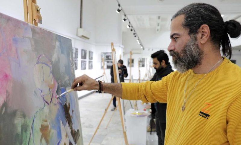 Iraqi painters participate in an art exhibition organized by Iraq's Ministry of Culture, Tourism, and Antiquities in Baghdad, Iraq, Dec. 15, 2024. The art exhibition, themed civil peace and combating extremism, featured several Iraqi painters' artworks which convey messages of rejecting violence and extremism. (Xinhua/Khalil Dawood)