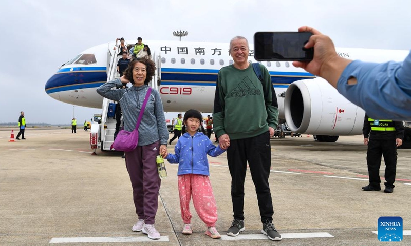 Passengers pose for photos with the C919 aircraft after getting off the plane at Haikou Meilan International Airport in Haikou, south China's Hainan Province, on Dec. 11, 2024. (Photo: Xinhua)