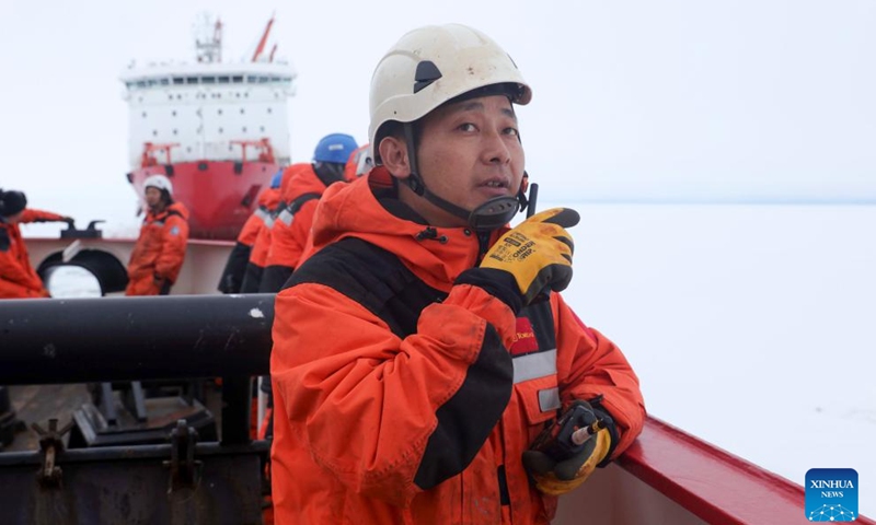 A member of China's 41st Antarctic expedition team directs unloading operations on China's research icebreaker Xuelong 2 in Antarctica, Dec. 8, 2024. (Photo: Xinhua)