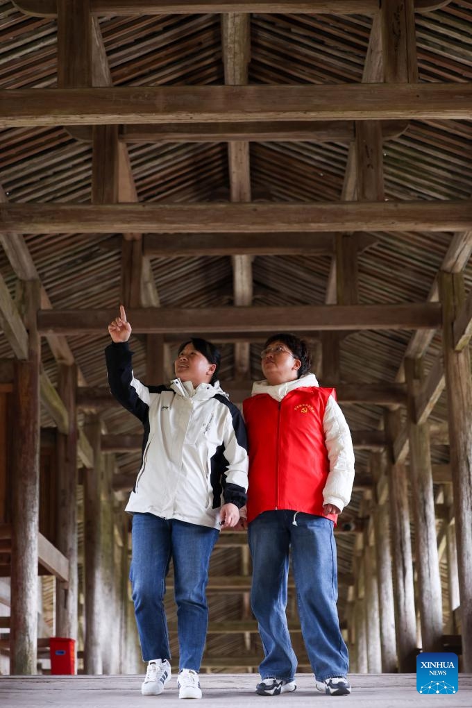 A staff member of cultural relics preservation and a volunteer patrol on the Xianju Bridge in Taishun County of Wenzhou City, east China's Zhejiang Province, Dec. 12, 2024. (Photo: Xinhua)