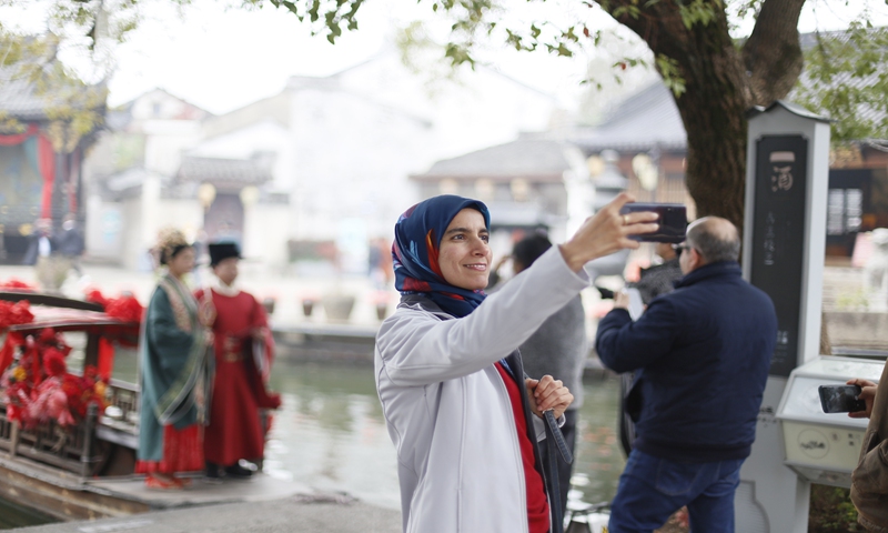 A participant of the Hernán Santa Cruz Dialogue on Economic, Social and Cultural Rights takes a selfie in the Huangjiu Town of Shaoxing, East China's Zhejiang Province, on December 7, 2024. Photo: Shan Jie/GT