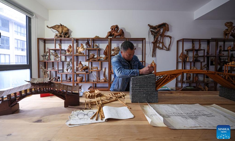 Zeng Jiakuai, a provincial-level inheritor of traditional design and practices for building Chinese wooden arch bridges, makes a bridge model at his studio in Taishun County of Wenzhou City, east China's Zhejiang Province, Dec. 11, 2024. (Photo: Xinhua)