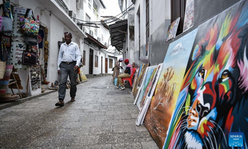 A man walks past an art shop in the Stone Town of Zanzibar, Tanzania, on Dec. 8, 2024. Stone Town, designated as a World Heritage Site by the United Nations Educational, Scientific and Cultural Organization in 2000, is a prime example of the Swahili coastal trading towns of East Africa. It retains its urban fabric and townscape largely intact, with many fine buildings reflecting a unique culture that blends African, Arabian, Indian, and European influences accumulated over more than a millennium. (Xinhua/Han Xu)