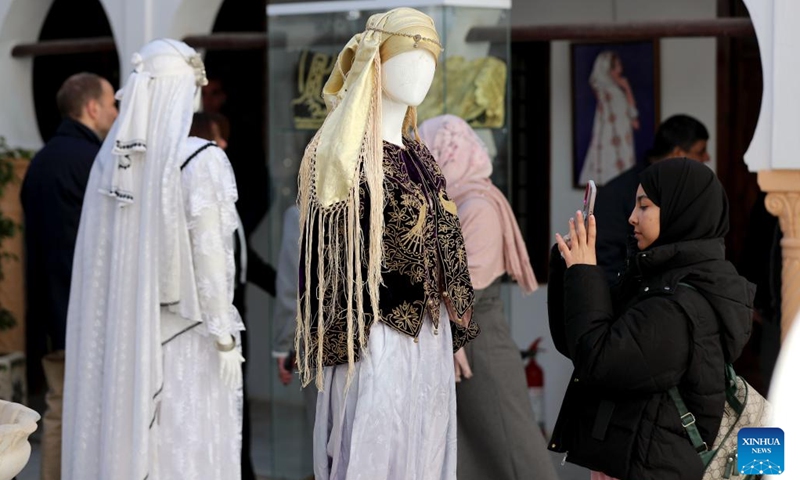 People view traditional women's attire displayed during an exhibition in Medea, Algeria, Dec. 12, 2024. (Photo: Xinhua)